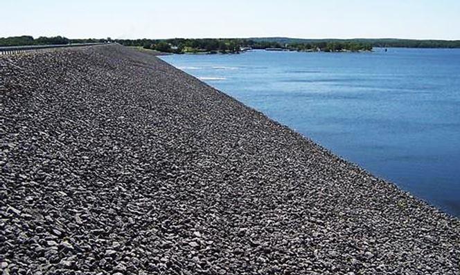 Riprap-covered dam face showing stabilized slope for erosion control and vegetation suppression, part of VegClear’s industrial dam and levee maintenance services