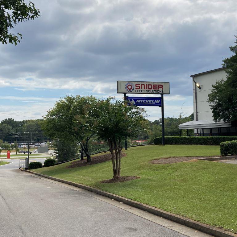 Entrance sign at Snider Fleet Solutions facility showing a landscaped logistics and truck service property with trimmed grass and clean access roads. Example industrial site for VegClear commercial weed control and vegetation management case study in Atlanta, Georgia