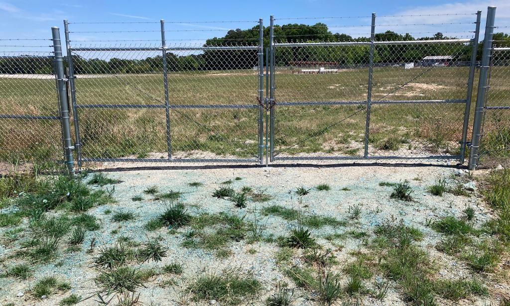 VegClear's treated industrial site representing licensed herbicide applications containing blue spray indicator to reflect where treatment has been applied