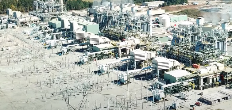 Aerial view of a high-voltage switching station with visible conductors and switchgear