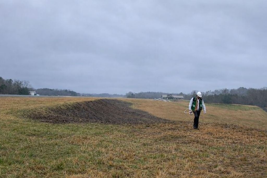 VegClear supervisor and business partner performing industrial vegetation management inspections and touch ups on a graded slope alongside a municipal airport runway, demonstrating hands on leadership, compliant herbicide application practices, and field level management for large scale commercial and municipal properties across South Carolina, Georgia, and the Southeast.