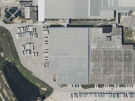 Aerial view of a large industrial distribution facility with extensive paved loading areas, trailers, and perimeter drainage zones. The image highlights areas where selective and total vegetation control programs prevent weed encroachment along pavement edges, retention ponds, and fence lines. Demonstrates VegClear’s large-scale herbicide application capabilities for logistics centers, warehouses, and manufacturing properties across Georgia, South Carolina, and the Southeast, maintaining safety, visibility, and compliance in high-traffic industrial environments.