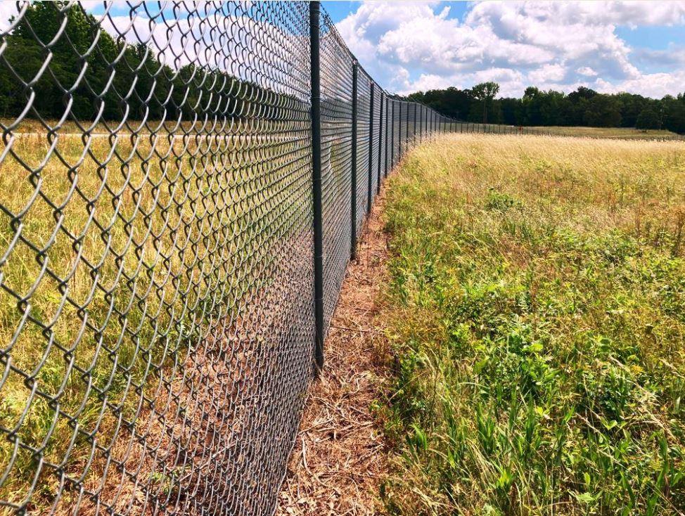 Industrial development property fence line vegetation control services by VegClear for substations and commercial locations with weeds growing
