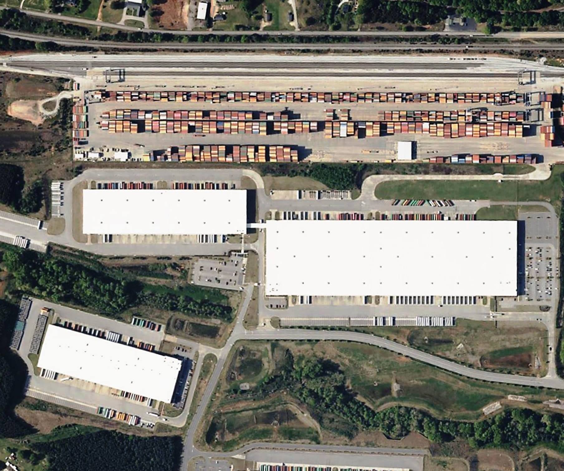 High-resolution aerial view of an industrial rail yard with shipping containers and surrounding infrastructure, representing the scale of sites VegClear serves. This image reflects VegClear’s industrial vegetation management and herbicide spraying work across Georgia and the Southeast for rail yards, airports, utilities, and commercial properties, ensuring safer, cleaner, and more efficient operations.