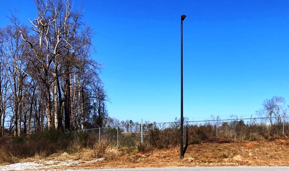 Airport Perimeter Fence with Dormant Kudzu – Winter Vegetation Management: Winter scene of an airport perimeter fence covered in dormant kudzu. Targeted herbicide applications during dormancy help control invasive vine growth and protect critical infrastructure from vegetation encroachment.