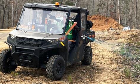 Off road UTV sprayer applying professional weed control on a commercial site. This setup is used for targeted herbicide spraying in hard to reach areas like gravel lots, slopes, and industrial properties where mowing is ineffective.