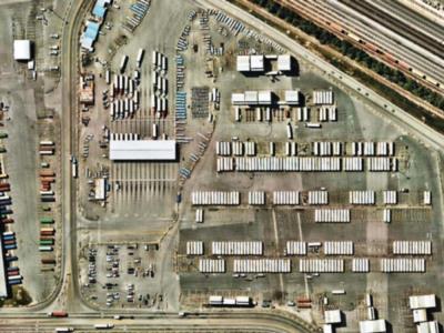 Clean rail spur and staging tracks at inland port, no weed growth in ballast or adjacent gravel pads, vegetation control maintained through non-selective herbicide treatment