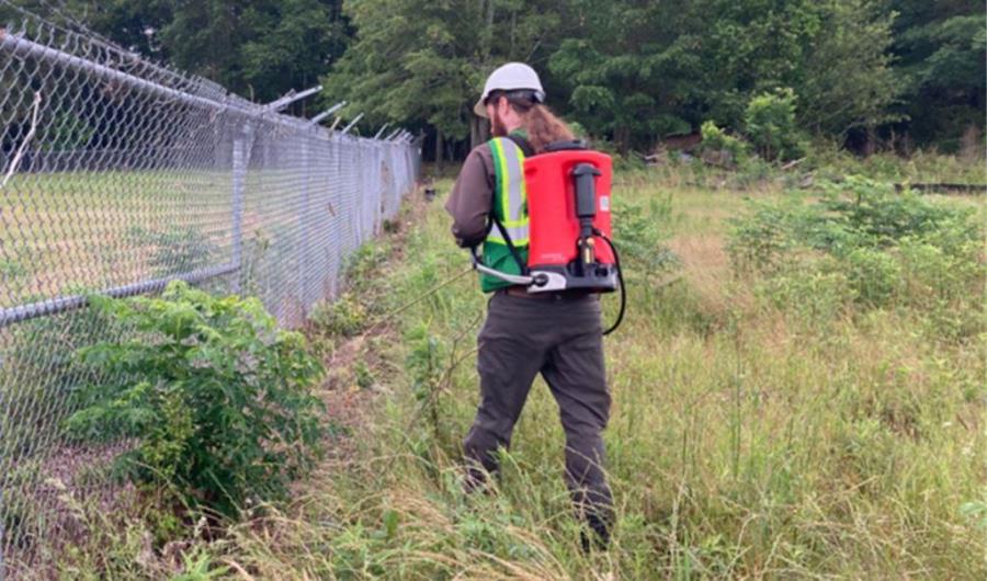 VegClear industrial weed control treatment along a fenced logistics yard in Georgia. Targeted herbicide application eliminates weeds along pavement and barriers for safer, low-maintenance property operations.
