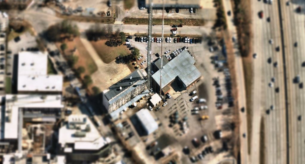 Aerial view of a secured communication tower site managed by BearCom and supported by Motorola Solutions technology. Surrounding gravel pads and fence lines are clear of vegetation, showcasing VegClear’s successful implementation of bare-ground herbicide applications to maintain operational efficiency