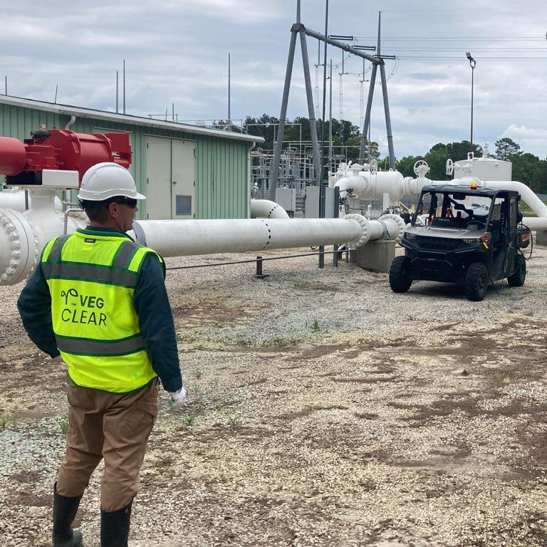 VegClear technician performing industrial gravel vegetation control at utility and gas transmission facility site.