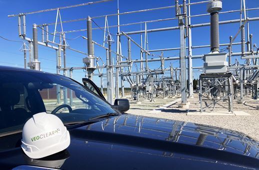 VegClear Truck parked alongside electric switching station while technician treats gravel with herbicide to kill weeds and prevent growth in South Carolina