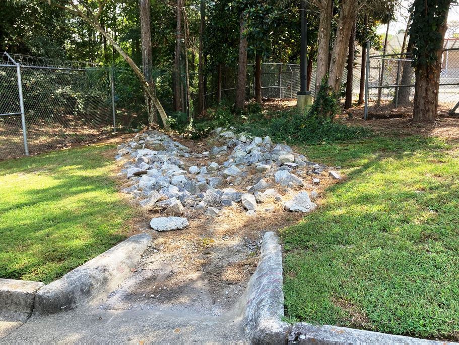 Bio Swales lined with rock for drainage need vegetation controlled lower volumes of water can be managed. When weeds die or decompose into soil, it further decreases the swales capacity.