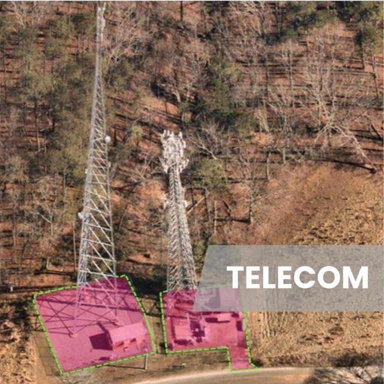 Aerial view of two cellular communication towers with defined equipment pads and access areas, showing vegetation management zones maintained for site access, safety, and regulatory compliance