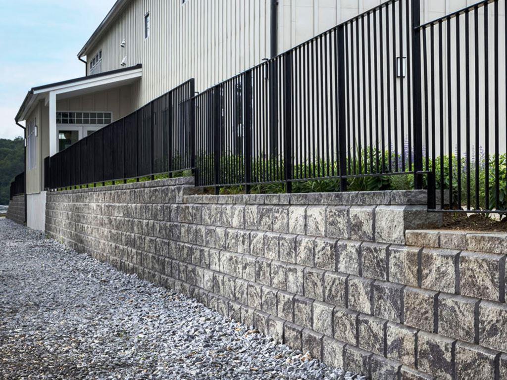 Forsyth County industrial park retaining wall and perimeter fence with gravel base kept clear through VegClear herbicide kudzu control program