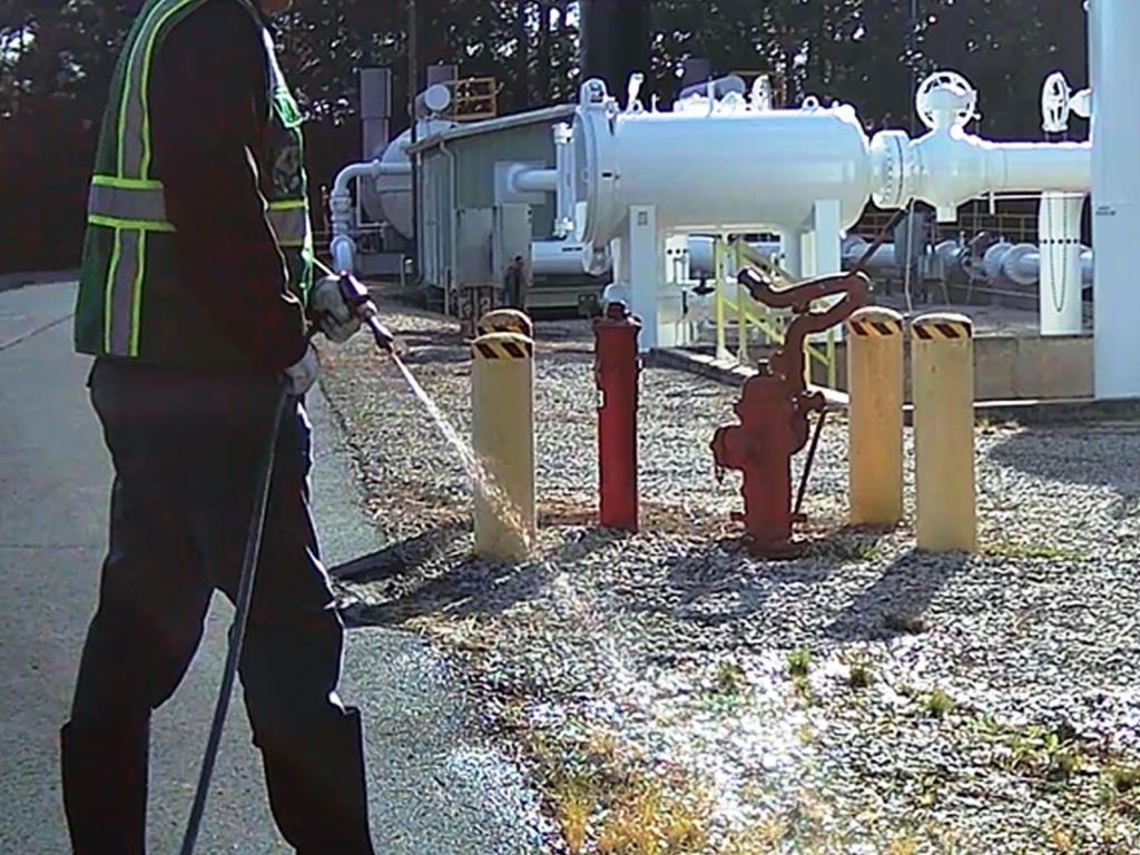 VegClear technician applying herbicide treatment at an industrial utility site in Georgia to maintain bare ground conditions around valves and equipment, ensuring compliance, safety, and vegetation-free operational zones.