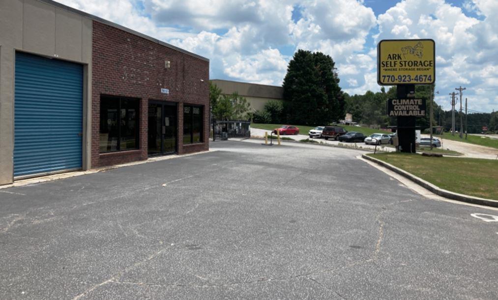 Front view of Ark Self Storage in Norcross, GA with parking lot and roadside sign, linking to VegClear’s vegetation control case study