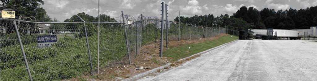 Perimeter fence line at an industrial site in Ellenwood, GA showing cleared and treated ground after VegClear’s vegetation management service. The contrast between previously overgrown sections and newly maintained areas demonstrates effective brush and vine control. This treatment improves visibility, strengthens fence security, and reduces the long-term maintenance burden for industrial operators like Snider Fleet Solutions.