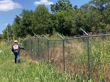 Technician Spraying Fenceline for Vegetation Control in Landscapes, Government, Industrial, Rail, Retail, and Utility Sites Throughout Georgia, Southeast
